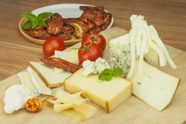 Slicing cheese, preparing for the home garden party. Delicious canapes for guests. Chef prepares lined dish for a festive reception. Production of small household farms.