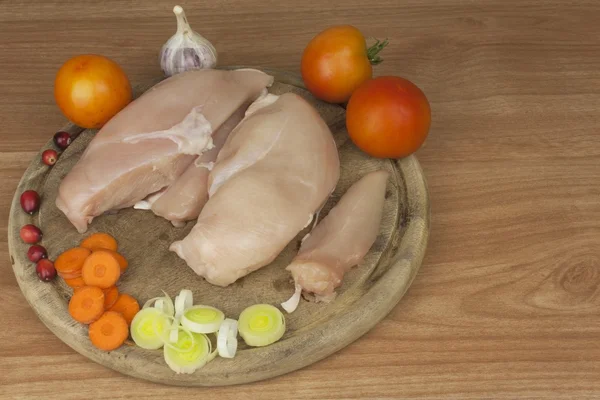 Fresh raw chicken fillet and vegetables prepared for cooking. Fresh raw chicken breasts. Preparing chicken at a summer barbecue. Cooking with fresh dietary ingredients.