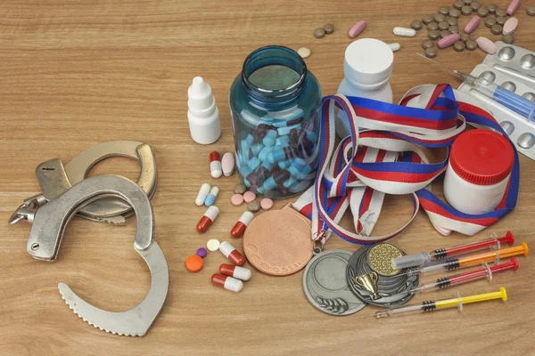Doping in sport. Abuse of anabolic steroids for sports. Anabolic steroids spilled on a wooden table. Fraud in sports. Pharmaceutical industry. Sports fraud, fake winner.