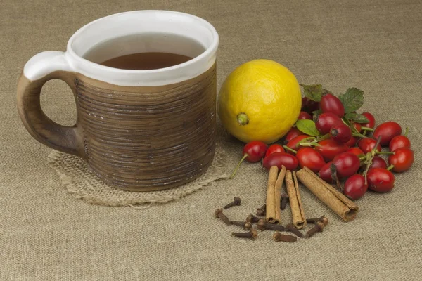 A flu epidemic. Traditional home treatment for colds and flu. Rosehip tea, honey and citrus. Hot tea with honey and lemon on a tabletop. Home Pharmacy. Proven treatment of diseases.