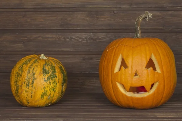 Halloween pumpkin head on wooden background. Preparing for Halloween. Head carved from a pumpkin on Halloween. Pumpkin tradition. Place for your text. Invitation for halloween. Scary Halloween pumpkin