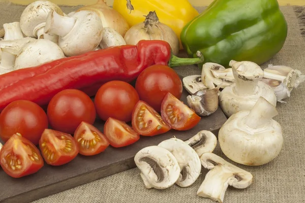 Raw mushrooms on a cutting board. Preparation of Champignons in the kitchen. Spices for food preparation. Vegetables to prepare meals