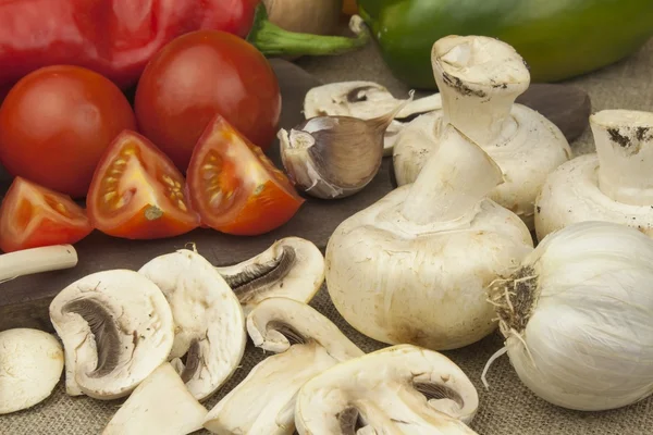 Raw mushrooms on a cutting board. Preparation of Champignons in the kitchen. Spices for food preparation. Vegetables to prepare meals