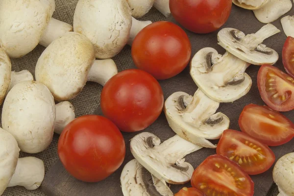 Raw mushrooms on a cutting board. Preparation of Champignons in the kitchen. Spices for food preparation. Vegetables to prepare meals