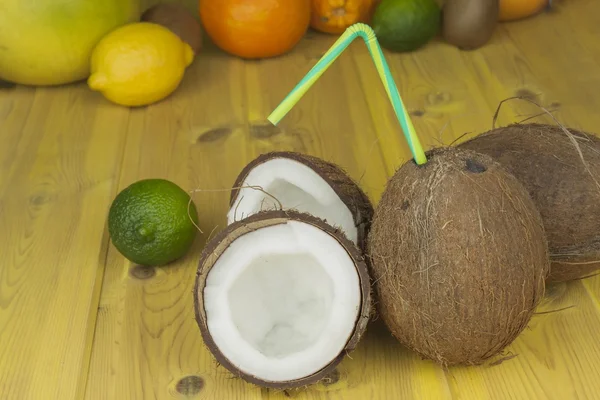 Cracked coconut on yellow wooden table. Preparing coconut refreshing drink. Tropical drink. The table at the beach bar. A refreshing drink made from coconut milk.