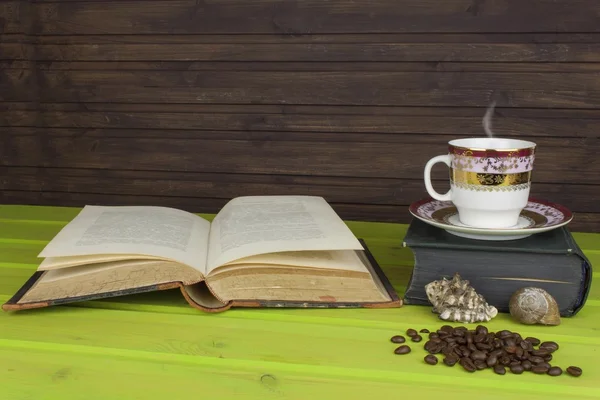 Cup of hot coffee and old book. Relaxing at the coffee. Studying old books. Place for your text. Cup of coffee on a wooden table. Vintage old books on wooden deck tabletop with cup of coffee.