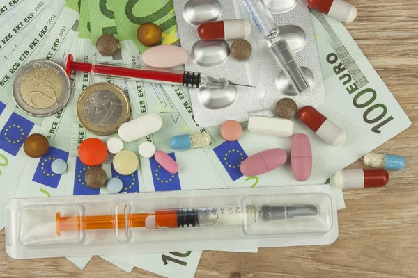 Money for expensive treatment. Money and pills. Pills of different colors on money. Genuine euro banknotes.  Health financing.