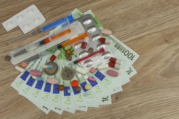 Money for expensive treatment. Money and pills. Pills of different colors on money. Genuine euro banknotes.  Health financing.