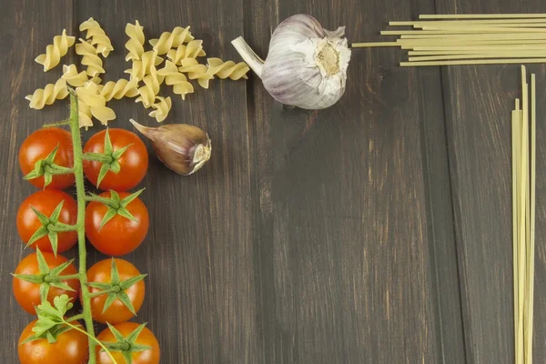 Preparation menu. Pasta and vegetables on a wooden table. Dietary food. Pasta, tomatoes, onion, olive oil and basil on wooden background.