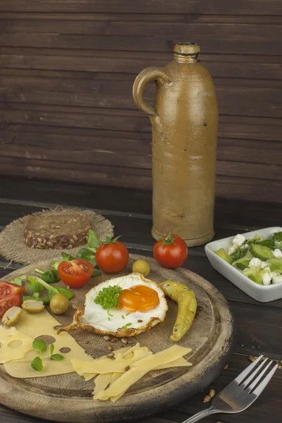 Fried Eggs on a wooden background. Fried eggs and vegetables on the cutting board. Homework healthy food.