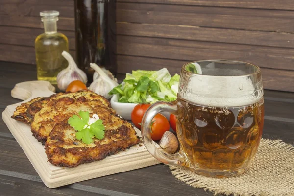 Fried potato pancakes with garlic. Traditional Czech food. Preparing homemade food. Potato pancakes and beer glasses.