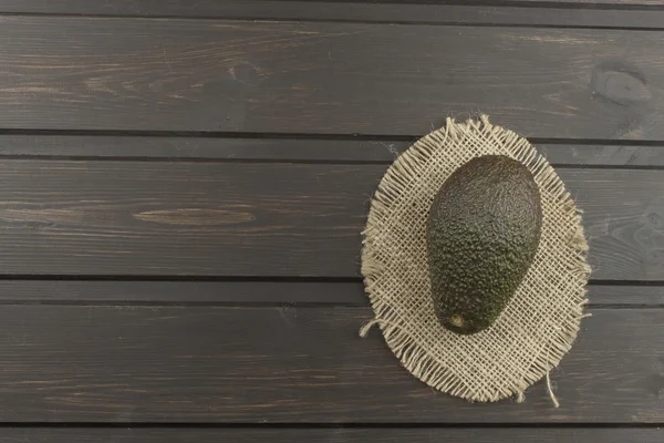 Fresh ripe avocado on a wooden background. Food background with fresh organic avocado. Avocado on a dark wood background.