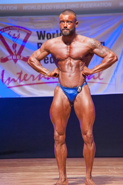 Male bodybuilder flexes his muscles to show his physique