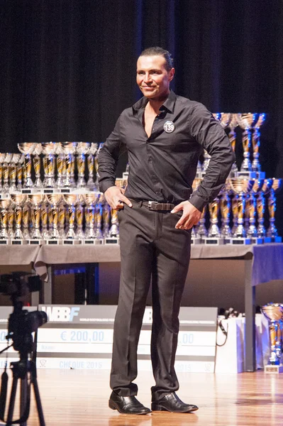 Male physique model shows his best in suit on stage