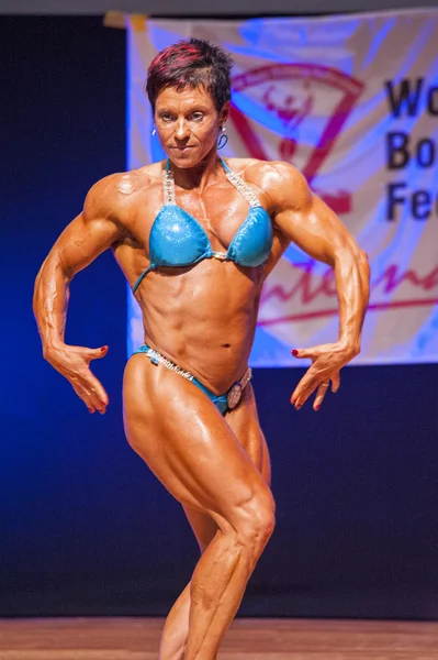 Female bodybuilder flexes her muscles to show her physique