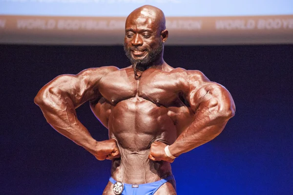 Male bodybuilder flexes his muscles and shows his best physique