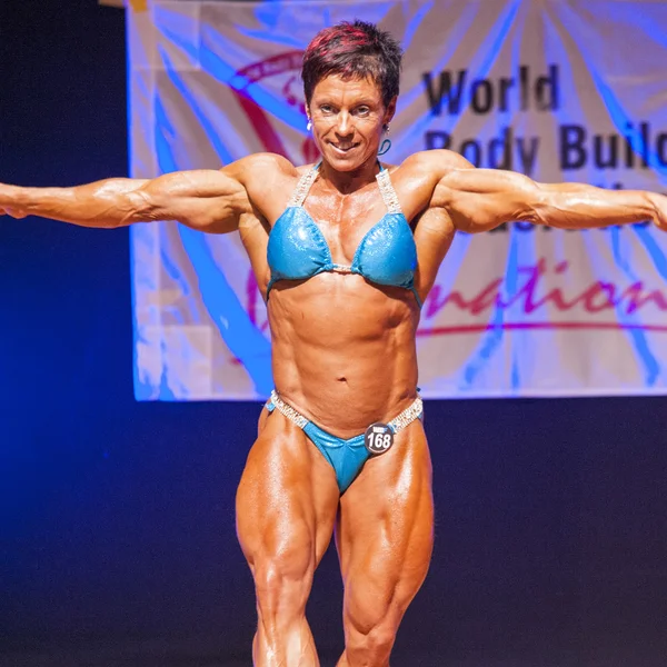 Female bodybuilder flexes her muscles to show her physique