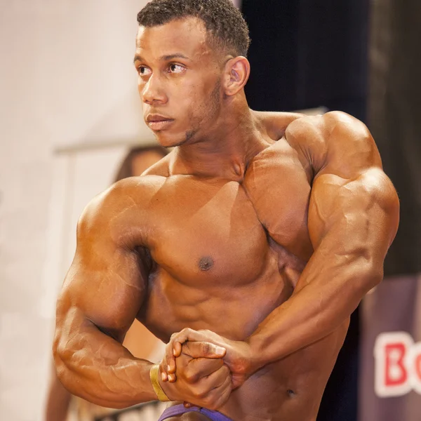 Male bodybuilder shows his best chest pose on stage