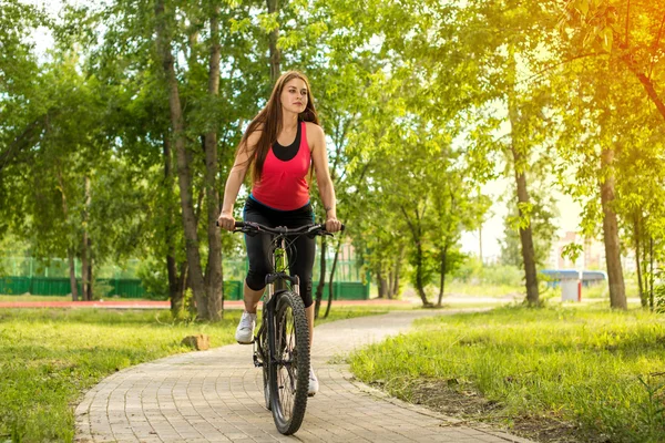 Happy girl cyclist riding on a mountain bike outside