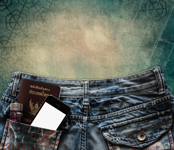 Blue jeans with cell phone, flashlight and passport in a pocket