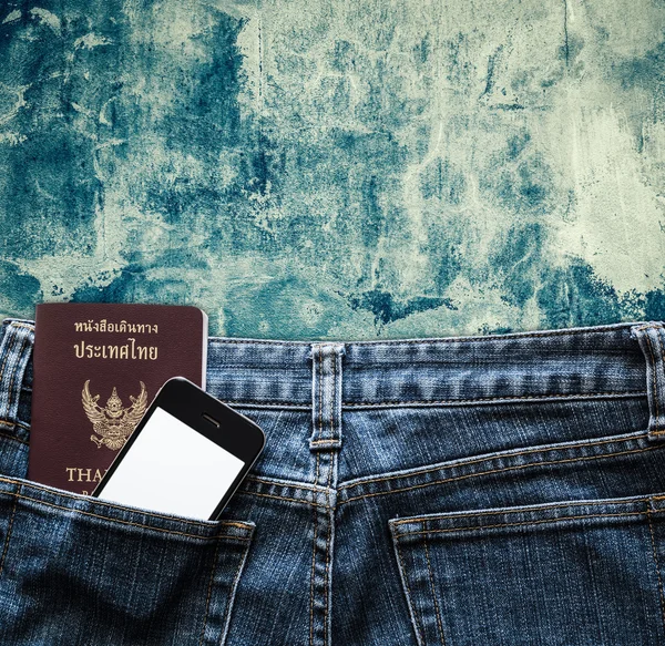 Blue jeans with cell phone and passport in a pocket background