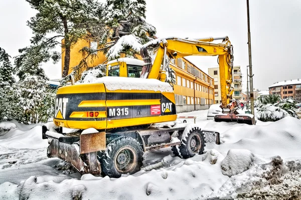 METKOVIC, CROATIA - FEBRUARY 12: Excavator cleans the streets of large amounts of snow in Metkovic, Croatia on February 12, 2012.