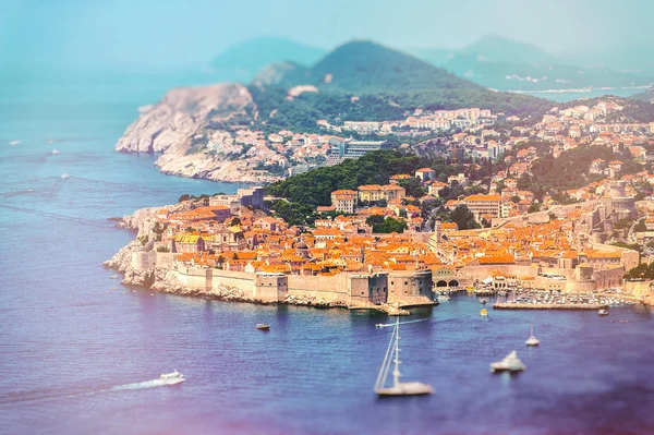 Panorama of Dubrovnik old city with many boats in front. Old vintage film processing.