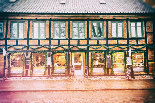 Exterior windows and facade of coffee shop where people rest and socialize during Christmas season in Sweden. Vintage old film processing.