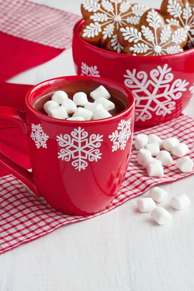 Mug filled with hot chocolate and marshmallows and gingerbread cookies