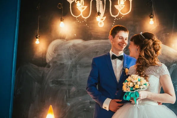 Bride and groom in the interior of the studio are on the background wall