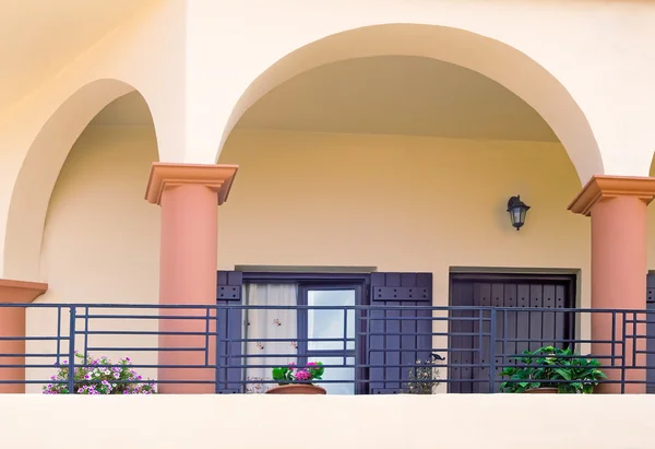 Detail of the facade of an old house with balconies and a sun aw