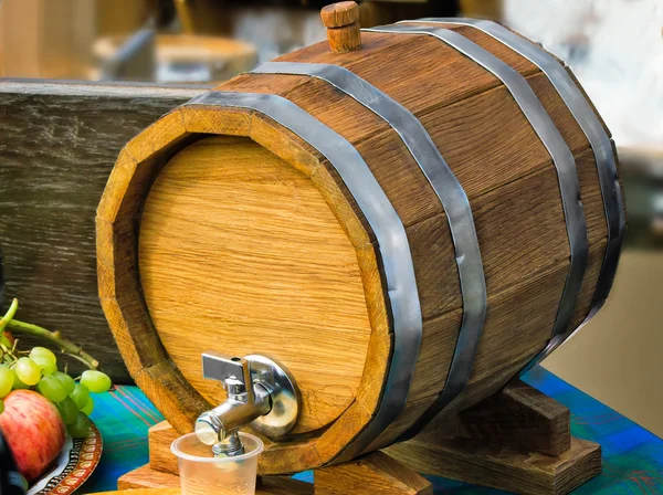 Wooden oak wine barrel with metal tap.