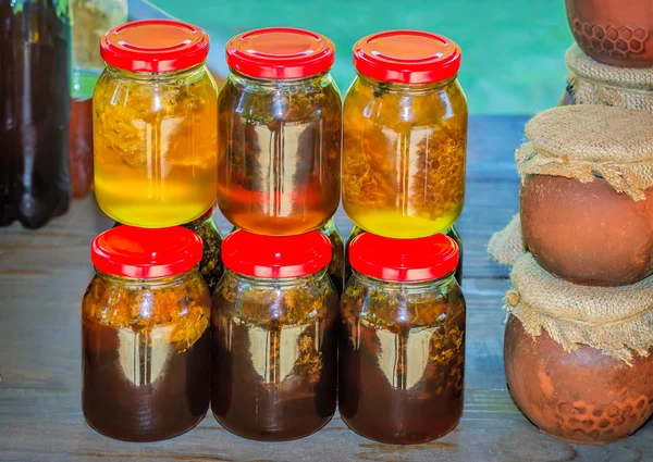Different varieties of honey in banks, offered for sale