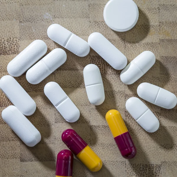 Many painkiller pills on a textured background