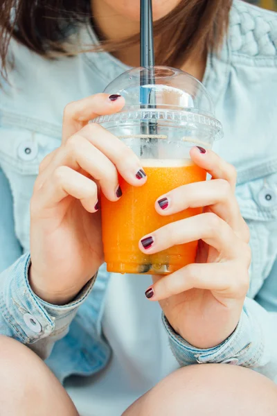 Teen girl hands with a fruit smoothie