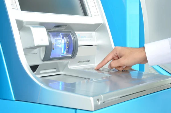 ATM with hand pressing on the keypad