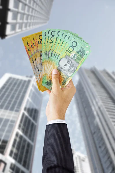 Hand holding Australian dollar banknotes