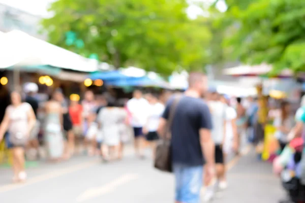 Blurred image of crowd walking in outdoor market