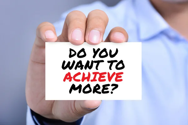 DO YOU WANT TO ACHIEVE MORE ?, message on the card held by a man