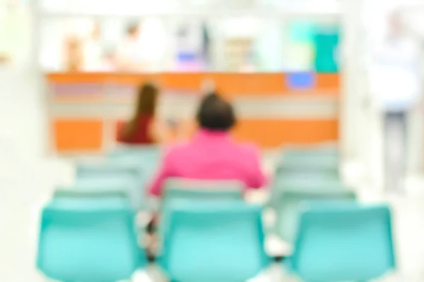 Blurred (back view) image of people sitting in hospital lobby