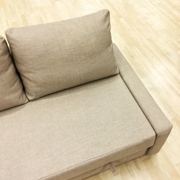 Elegant sofa-bed on wooden floor