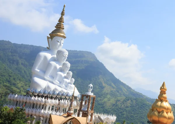 White statue of Buddha with blue sky in the temple