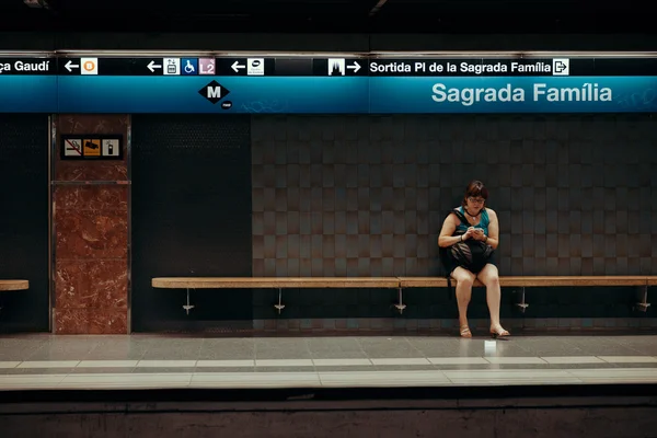 Girl wait train in Sagrada Familia subway sign