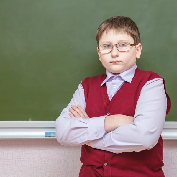 Boy standing with his arms crossed at a school board