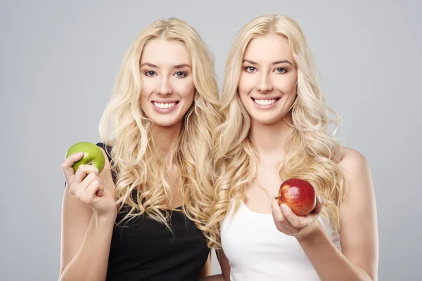 Twins holding apples