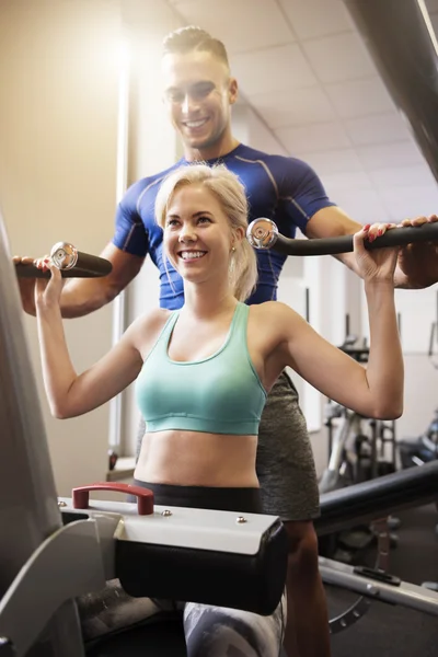 Woman exercising with instructor at the gym