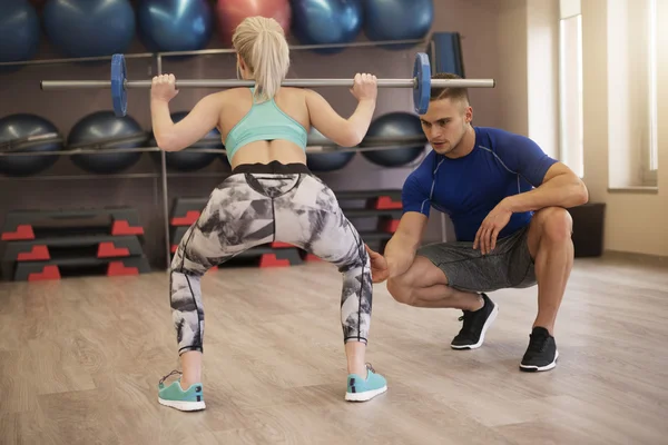 Woman working out with Trainer at the gym