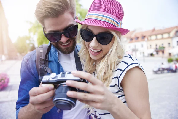 Couple looking on camera screen with pictures