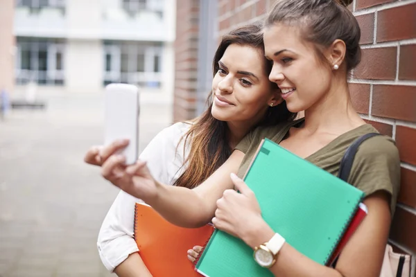 Best friends taking selfie on mobile phone