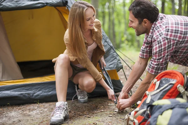 Couple helping each other on camping